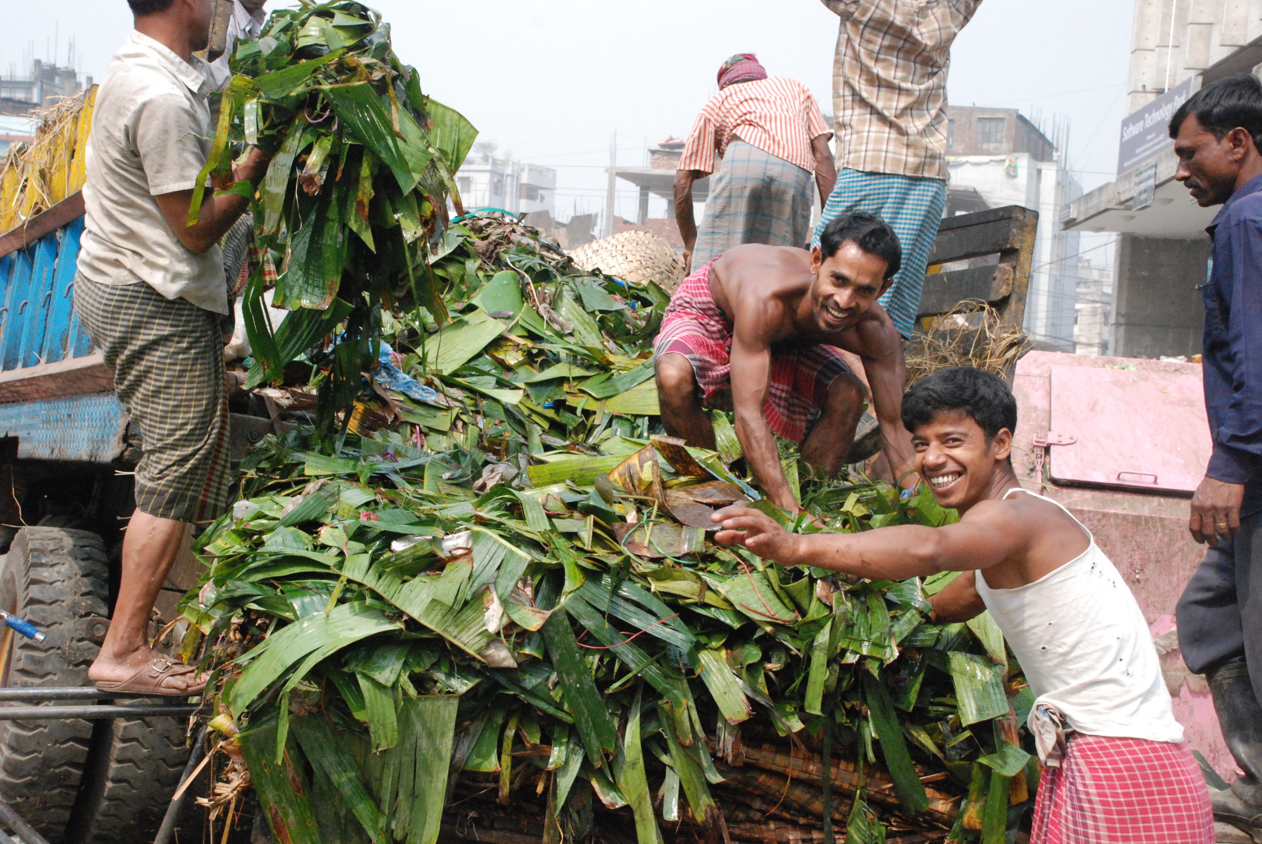 Two farmers unload the back of a truck in Bangladesh. (GAIN)