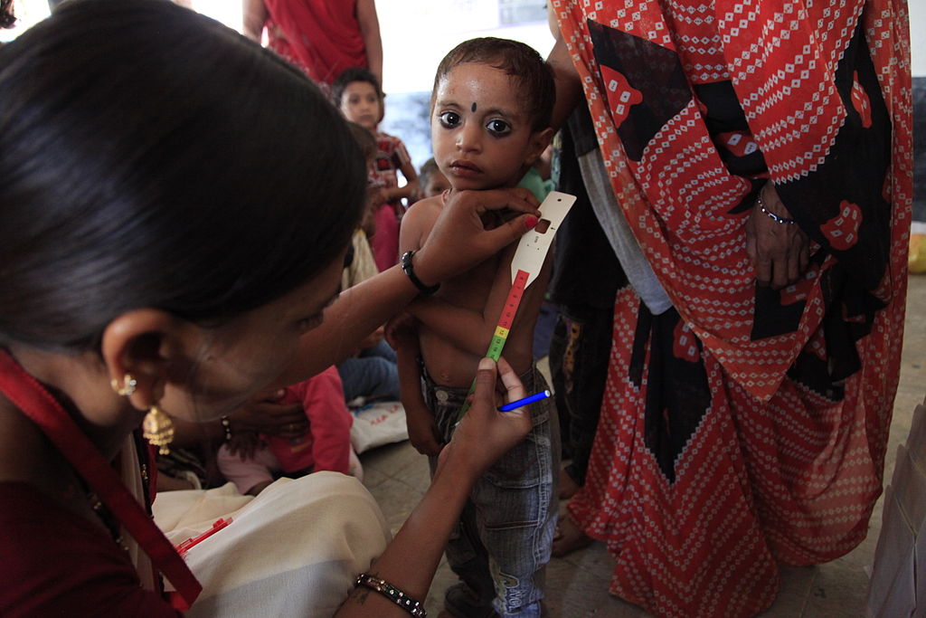 A child’s upper arm is measured at an Anganwadi centre in the village of Baggad, in Madhya Pradesh’s Dhar district. (Photo: Russell Watkins/DFID)