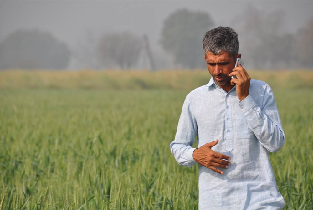 Farmer in field talking on the phone