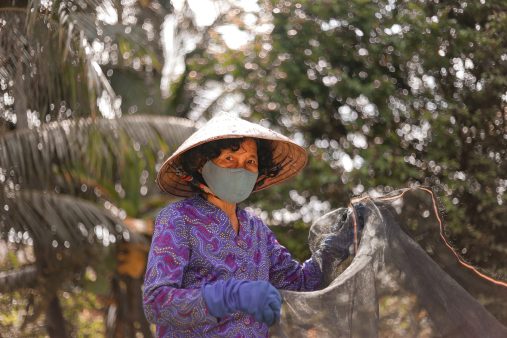 Rural woman holding net and looking at the camera