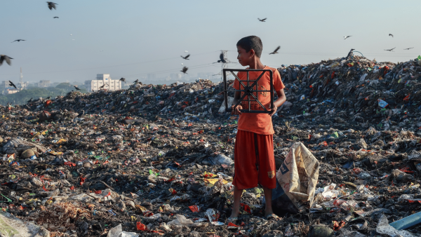 Boy on dumpsite filled with food waste harming the environment